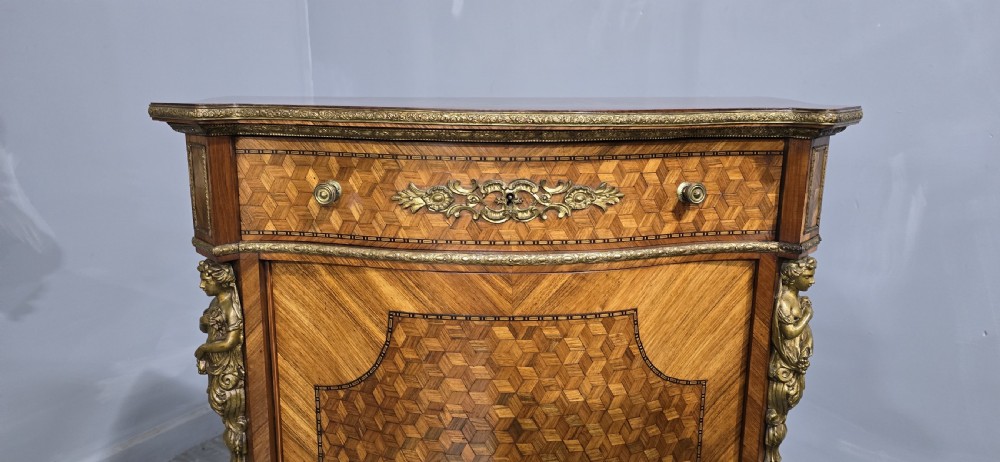 A French Louis XV style serpentine side cabinet featuring geometric cubework parquetry inlay, a single door, and decorative gilt-bronze mounts. View VI