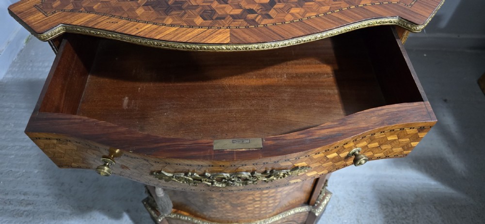 A French Louis XV style serpentine side cabinet featuring geometric cubework parquetry inlay, a single door, and decorative gilt-bronze mounts. View X