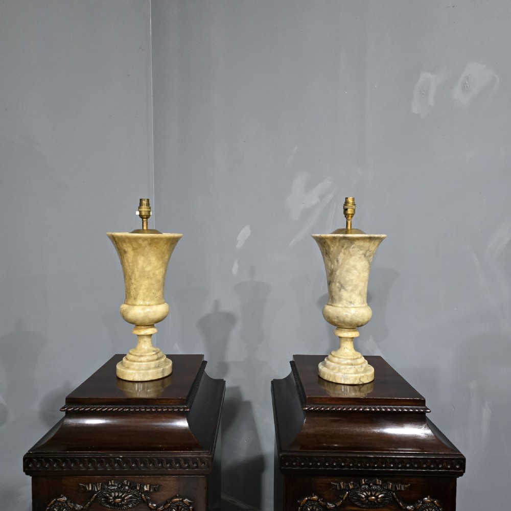 A pair of carved cream Italian marble urn-form table lamps with fabric shades trimmed in dark beaded fringe. View II