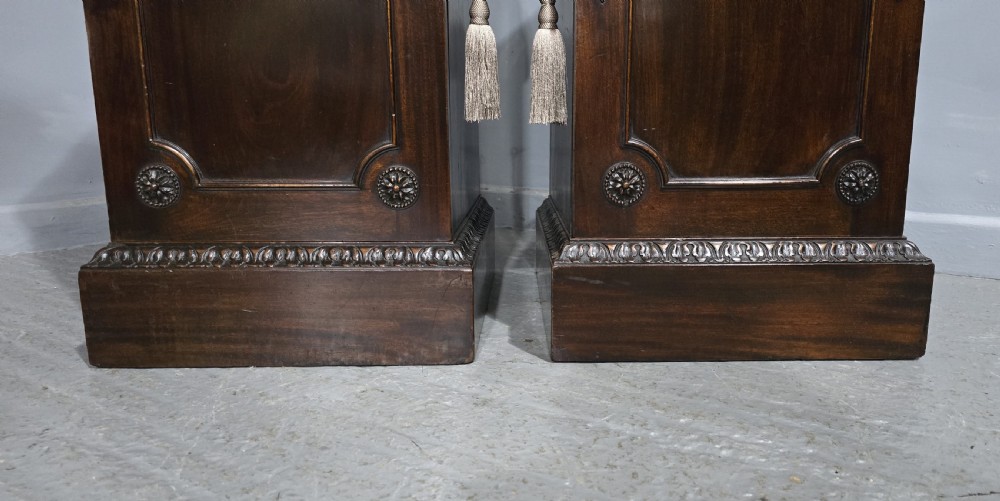 A pair of dark mahogany Regency style side cabinets featuring carved swags, floral rosettes, stepped tops, and plinth bases. View II