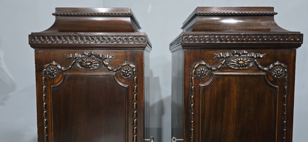A pair of dark mahogany Regency style side cabinets featuring carved swags, floral rosettes, stepped tops, and plinth bases. View IV