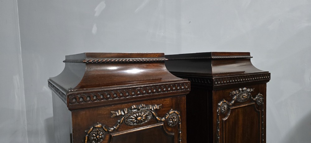 A pair of dark mahogany Regency style side cabinets featuring carved swags, floral rosettes, stepped tops, and plinth bases. View VIII
