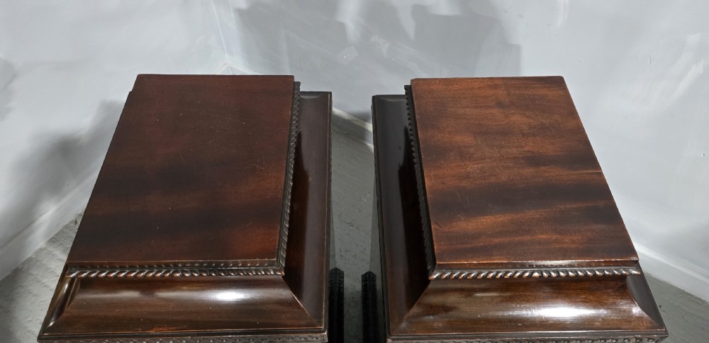 A pair of dark mahogany Regency style side cabinets featuring carved swags, floral rosettes, stepped tops, and plinth bases. View XXI