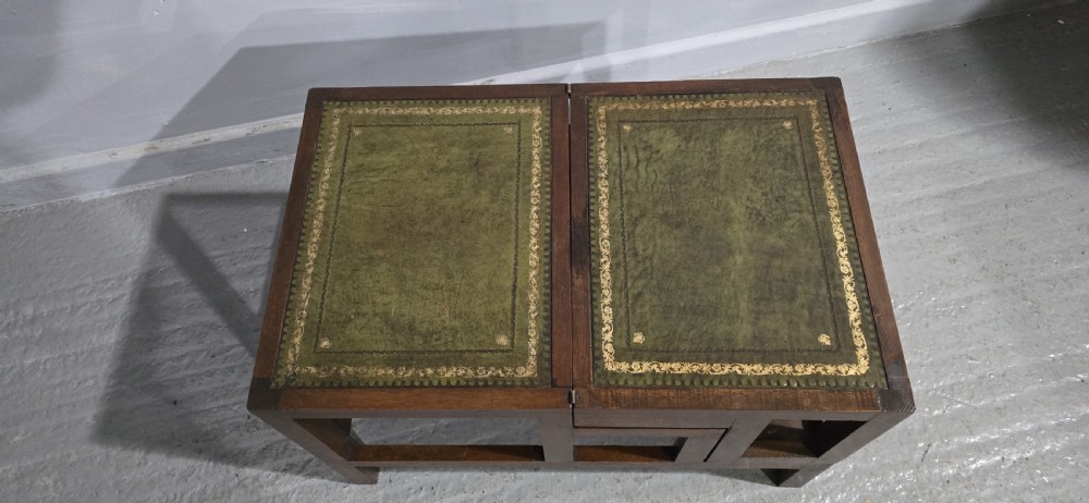 A set of dark mahogany library steps featuring four tiers inlaid with gold-tooled green leather treads. View V