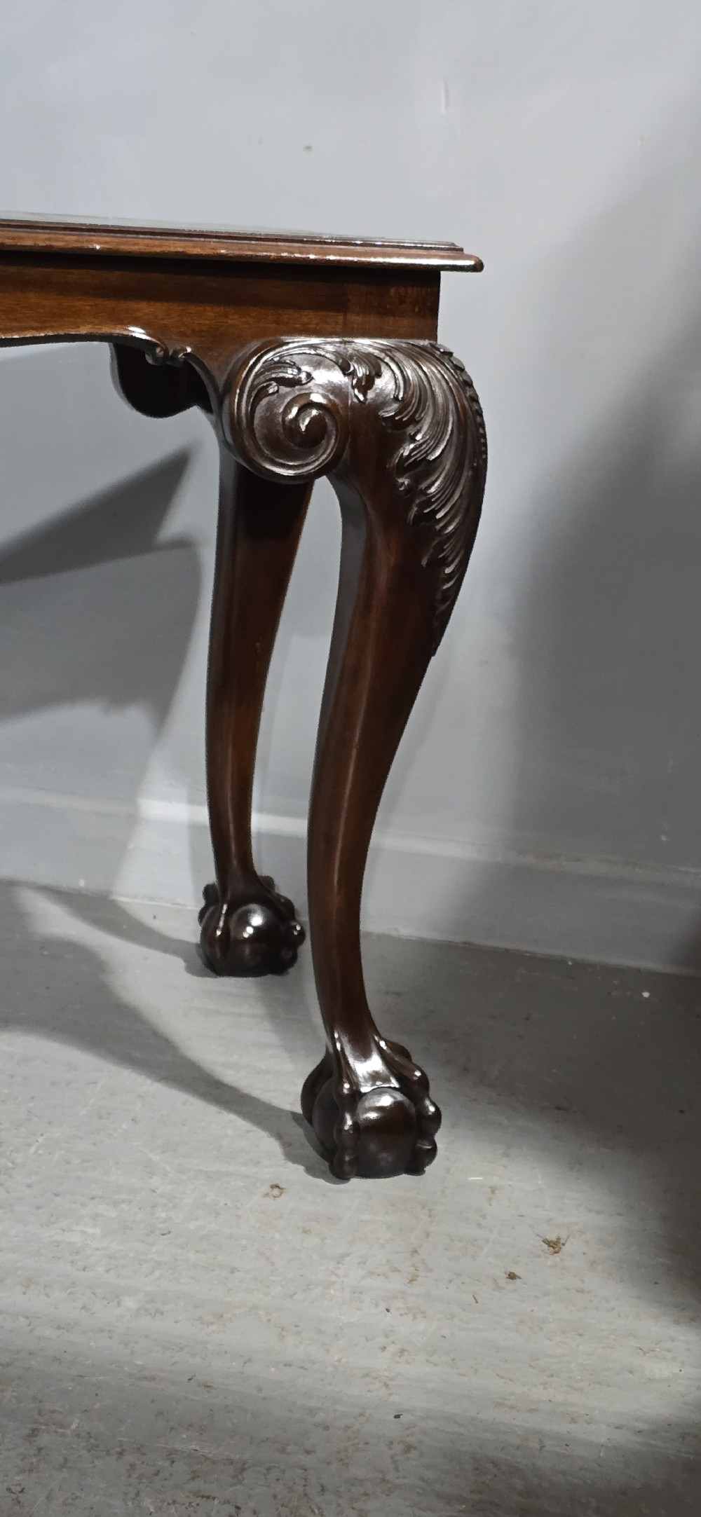 A mahogany console table featuring a green gold-tooled leather inset top and carved cabriole legs ending in ball-and-claw feet. View IV