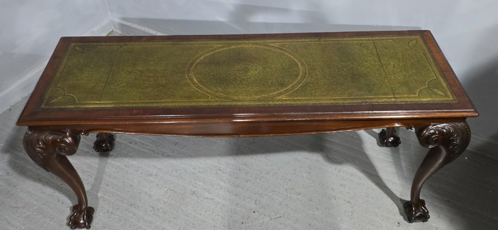 A mahogany console table featuring a green gold-tooled leather inset top and carved cabriole legs ending in ball-and-claw feet. View X