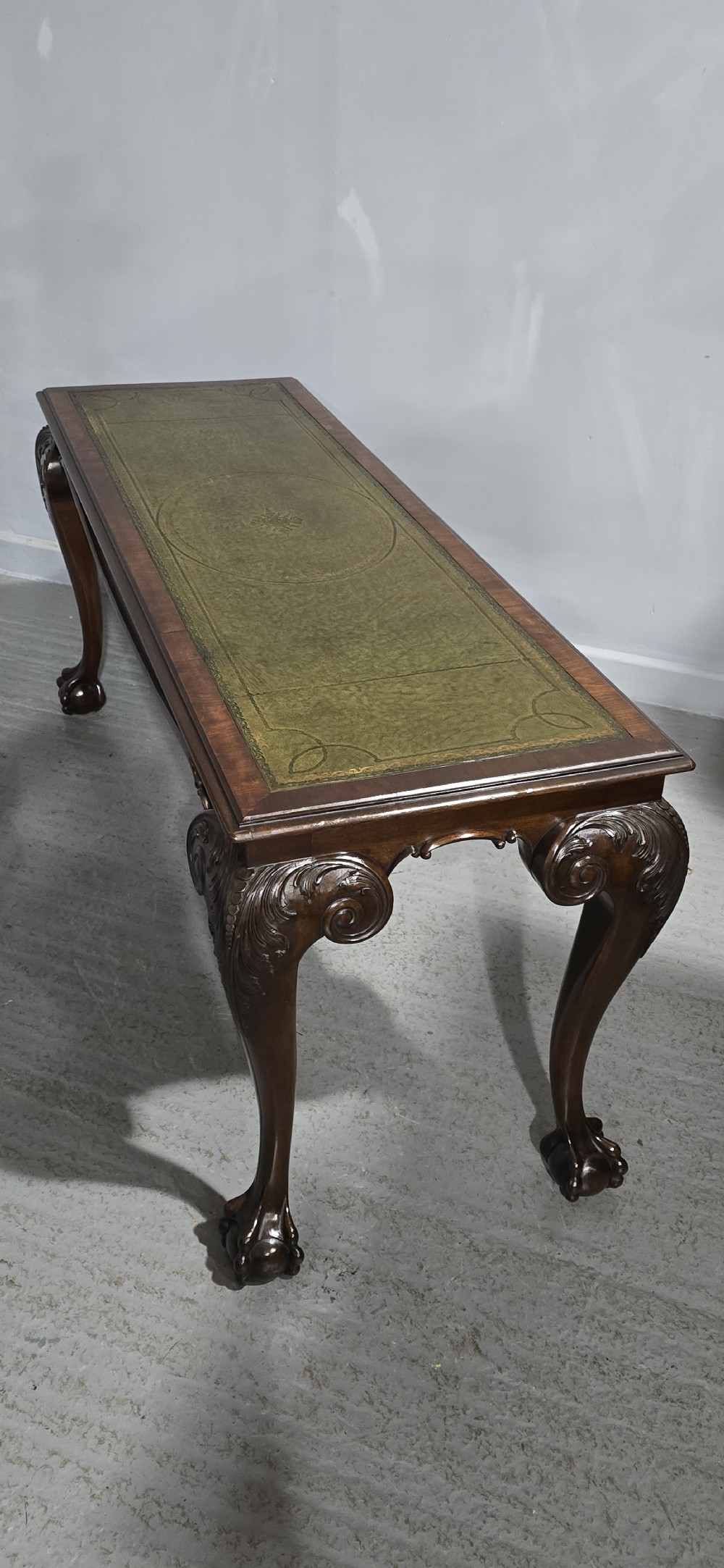 A mahogany console table featuring a green gold-tooled leather inset top and carved cabriole legs ending in ball-and-claw feet. View XVI