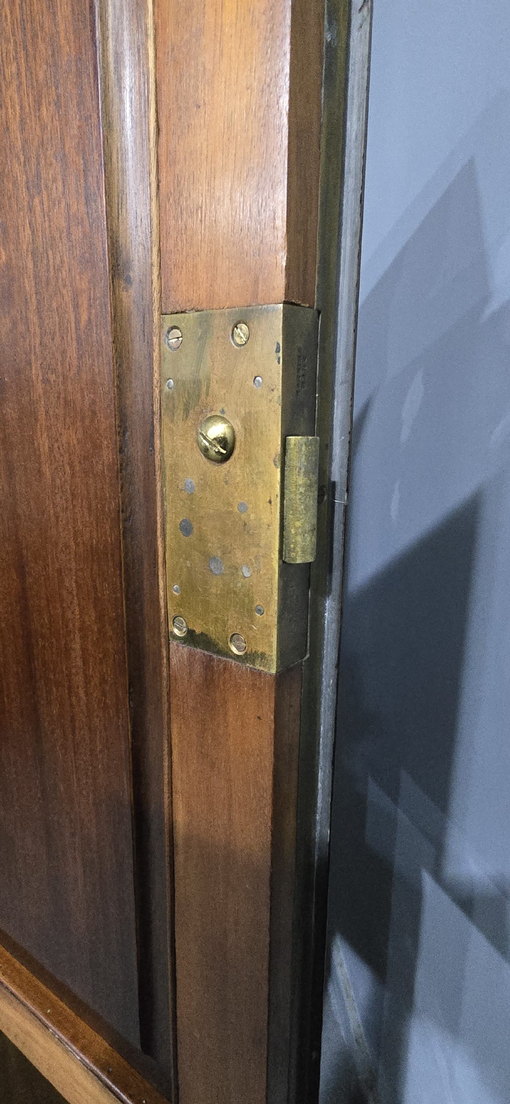 A tall mahogany linen press featuring a double-door upper cupboard with flame mahogany panels over four long drawers with turned knobs. View IX