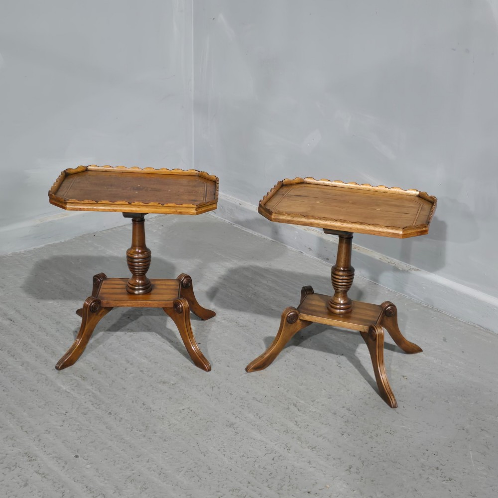A pair of matching English walnut wine tables featuring gallery tops with wood inlay, turned central pedestals, and splayed legs.