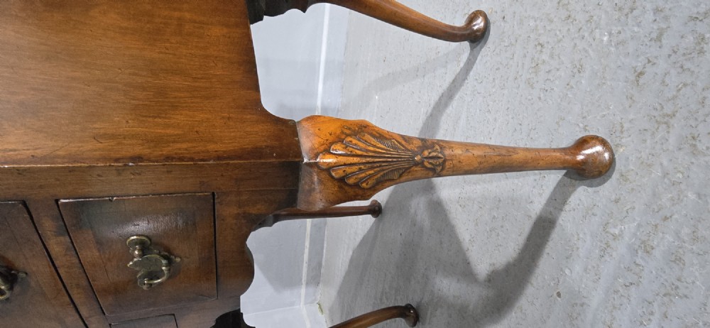 A Queen Anne style burr walnut lowboy table featuring cabriole legs with carved knees, pad feet, brass drop handles, and a shaped apron. View IV