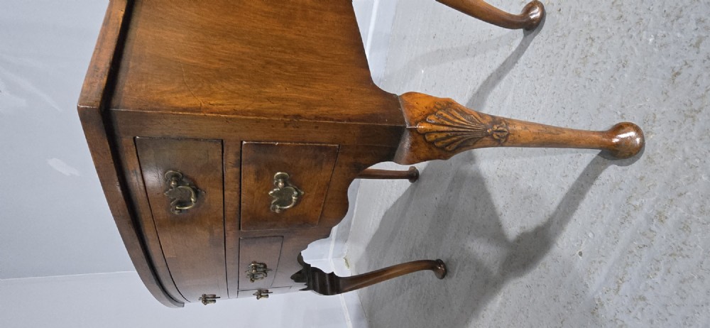 A Queen Anne style burr walnut lowboy table featuring cabriole legs with carved knees, pad feet, brass drop handles, and a shaped apron. View V