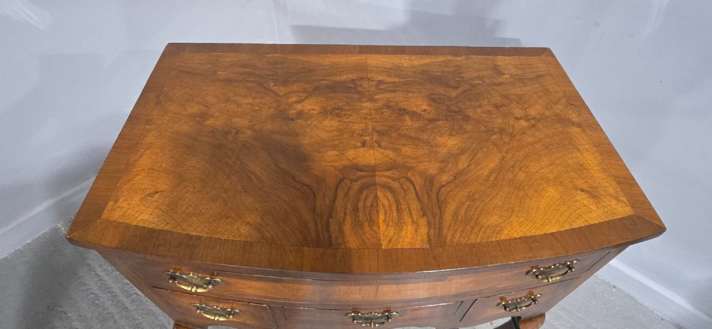 A Queen Anne style burr walnut lowboy table featuring cabriole legs with carved knees, pad feet, brass drop handles, and a shaped apron. View XII