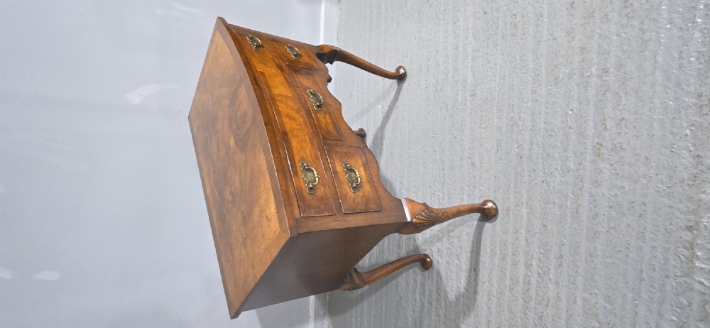 A Queen Anne style burr walnut lowboy table featuring cabriole legs with carved knees, pad feet, brass drop handles, and a shaped apron. View XIV