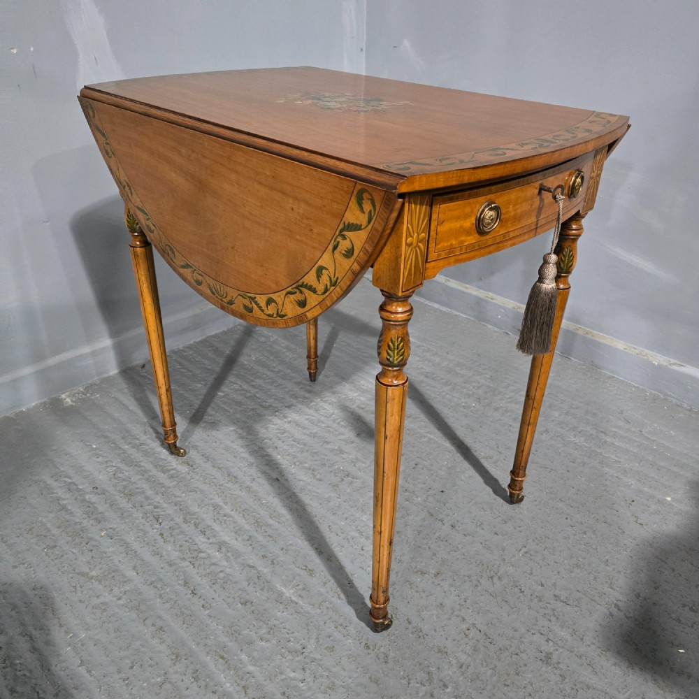 An antique painted satinwood Pembroke table featuring two drop leaves, hand-painted floral borders, turned tapering legs, and a single frieze drawer. View II