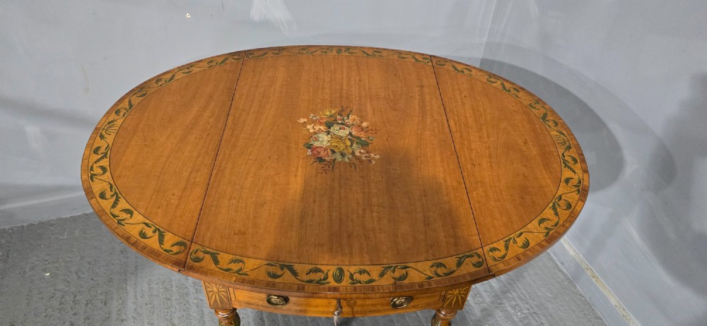 An antique painted satinwood Pembroke table featuring two drop leaves, hand-painted floral borders, turned tapering legs, and a single frieze drawer. View IV