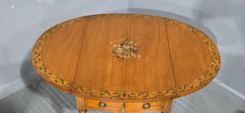An antique painted satinwood Pembroke table featuring two drop leaves, hand-painted floral borders, turned tapering legs, and a single frieze drawer. View VI