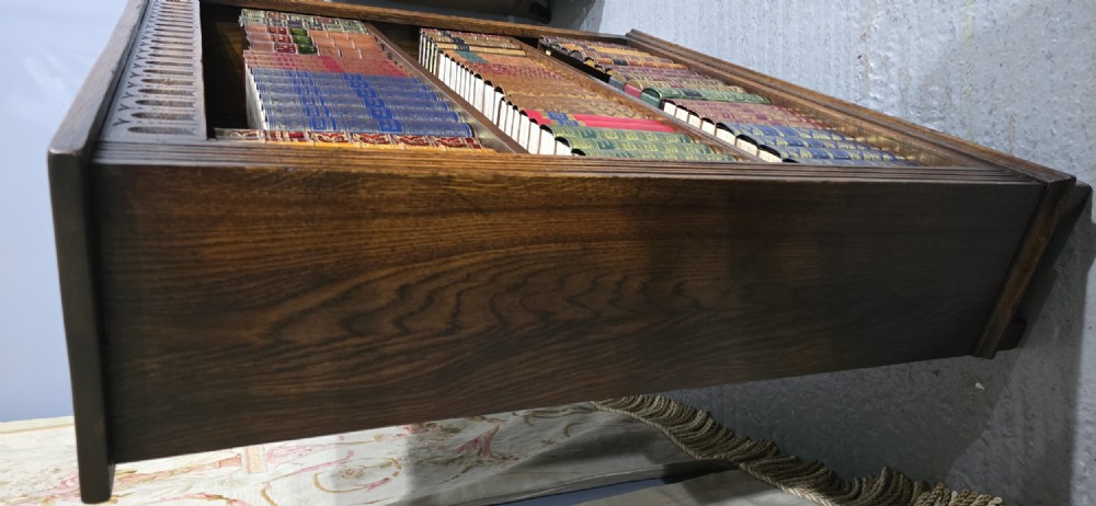 A low solid oak open bookcase with three shelves filled with antiquarian books, featuring a carved arcaded frieze and reeded side moulding. View V