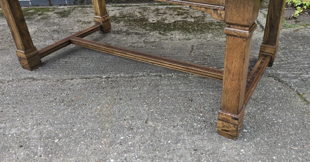A large rectangular French refectory dining table featuring a patterned parquet timber top, square block legs, and a low stretcher base. View III