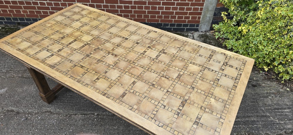 A large rectangular French refectory dining table featuring a patterned parquet timber top, square block legs, and a low stretcher base. View VII