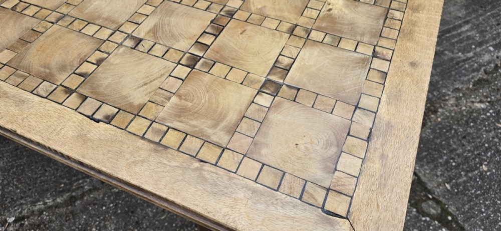 A large rectangular French refectory dining table featuring a patterned parquet timber top, square block legs, and a low stretcher base. View X