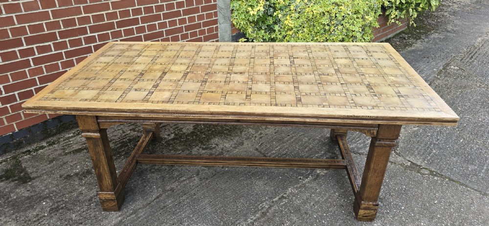 A large rectangular French refectory dining table featuring a patterned parquet timber top, square block legs, and a low stretcher base. View XIII