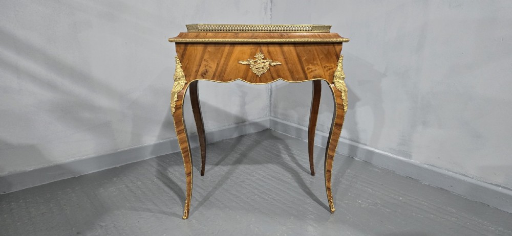 A Louis XV style satinwood jardiniere table featuring quartered wood veneer, ornate gilded bronze mounts, cabriole legs, a pierced brass gallery, and a metal liner. View II