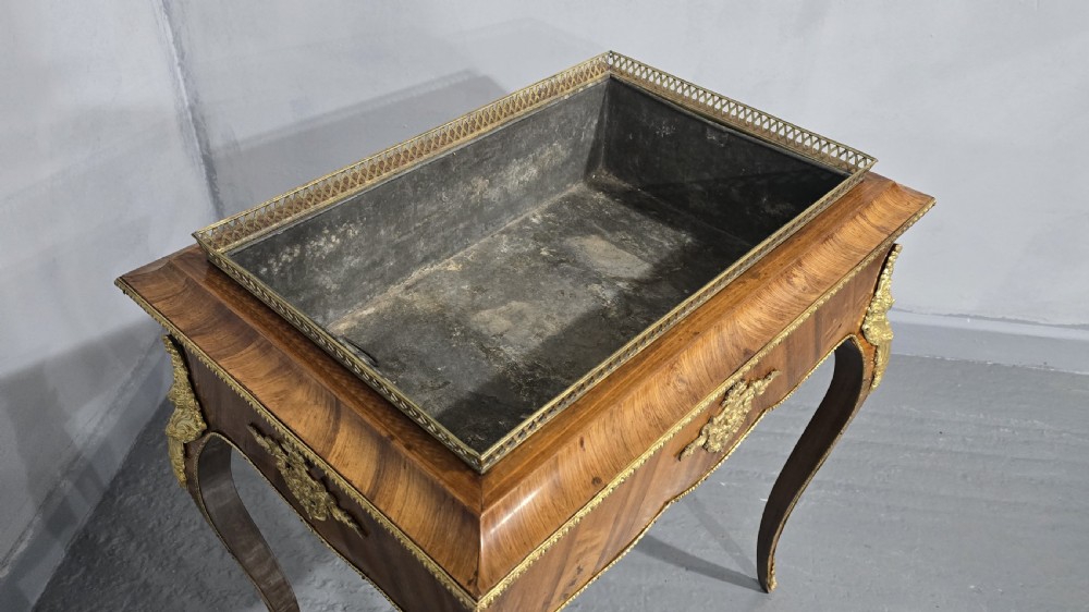 A Louis XV style satinwood jardiniere table featuring quartered wood veneer, ornate gilded bronze mounts, cabriole legs, a pierced brass gallery, and a metal liner. View VIII