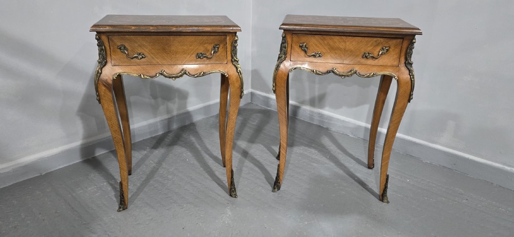 A pair of French Rococo style bedside tables with marquetry tops, single drawers, and ornate brass mounts on cabriole legs. View III