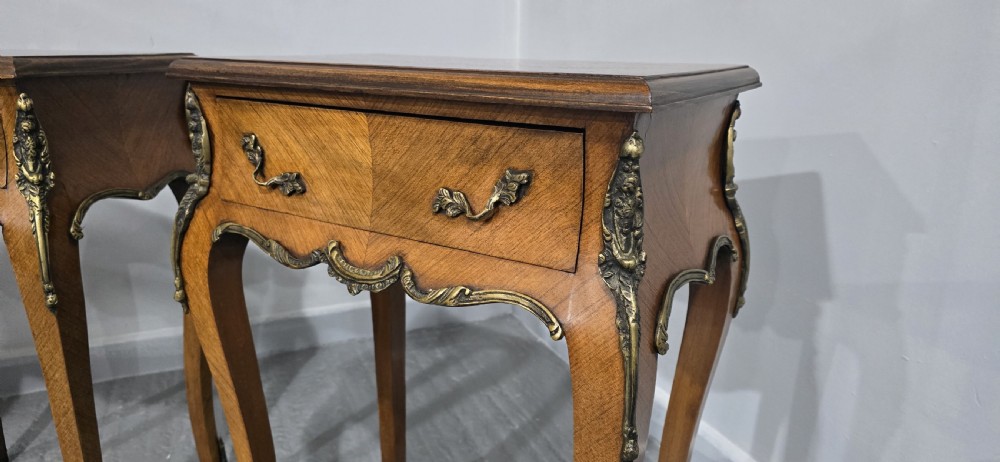 A pair of French Rococo style bedside tables with marquetry tops, single drawers, and ornate brass mounts on cabriole legs. View VIII