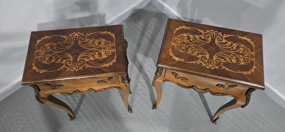 A pair of French Rococo style bedside tables with marquetry tops, single drawers, and ornate brass mounts on cabriole legs. View X