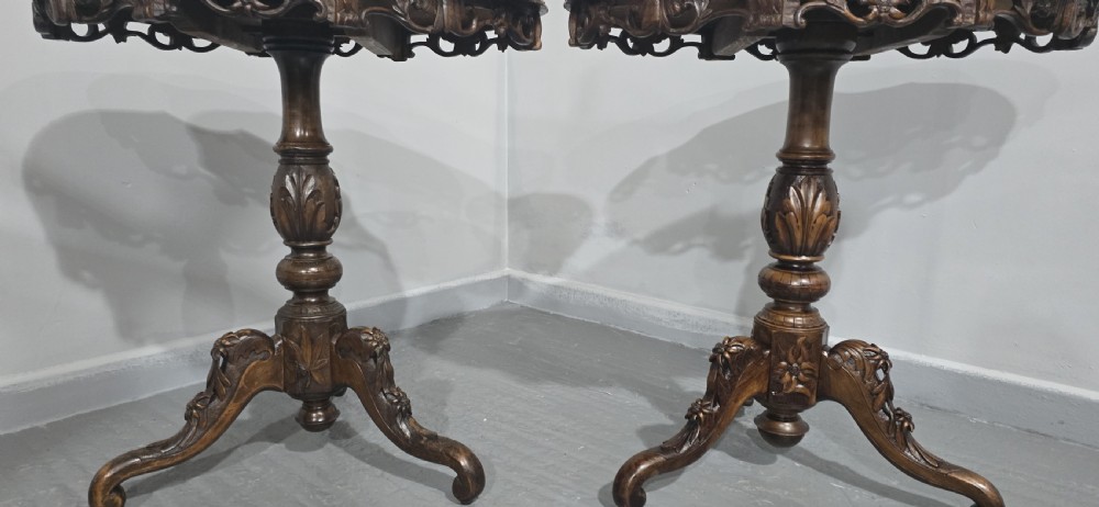 A pair of antique Black Forest carved walnut side tables featuring intricate marquetry tops with animal silhouettes on tripod pedestal bases. View VII