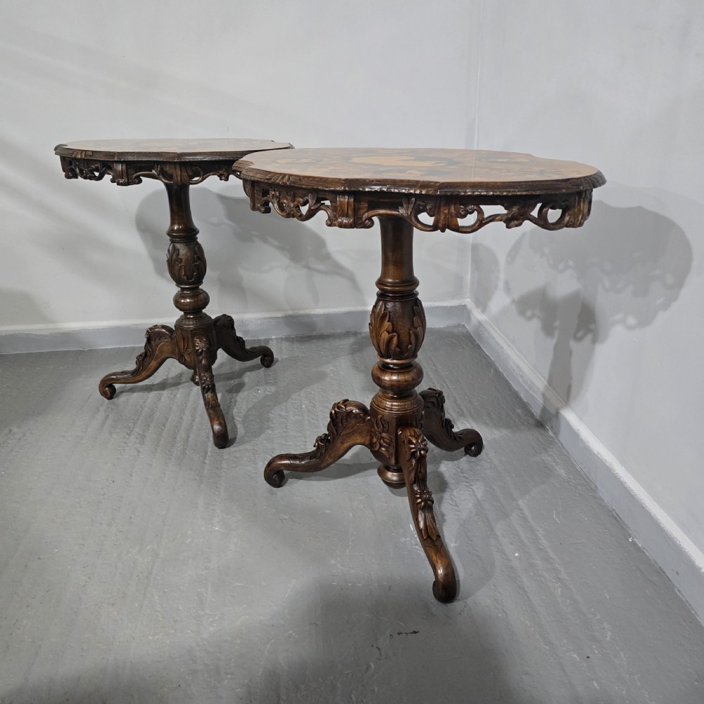 A pair of antique Black Forest carved walnut side tables featuring intricate marquetry tops with animal silhouettes on tripod pedestal bases. View XI