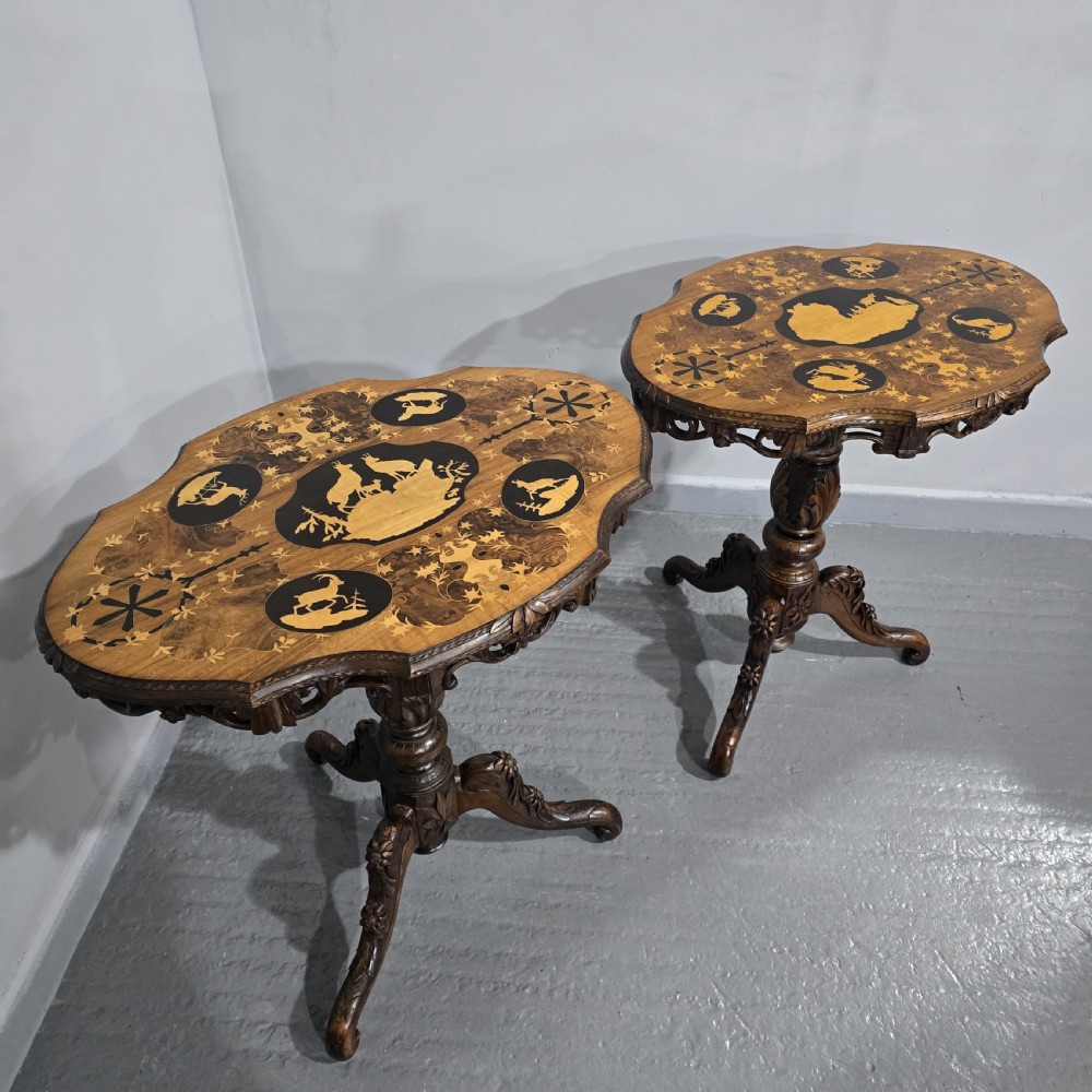 A pair of antique Black Forest carved walnut side tables featuring intricate marquetry tops with animal silhouettes on tripod pedestal bases. View XII