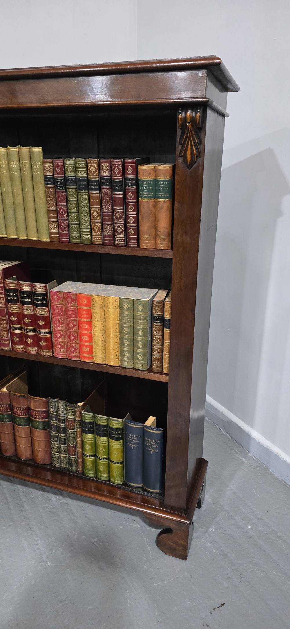 A Victorian mahogany open bookcase featuring three adjustable shelves filled with leather-bound books, flanked by carved corbels. View II