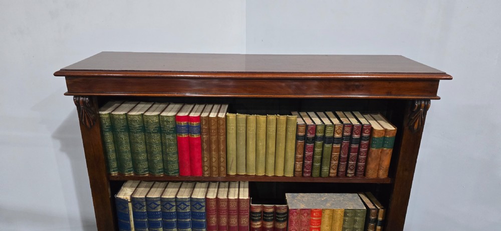 A Victorian mahogany open bookcase featuring three adjustable shelves filled with leather-bound books, flanked by carved corbels. View VI