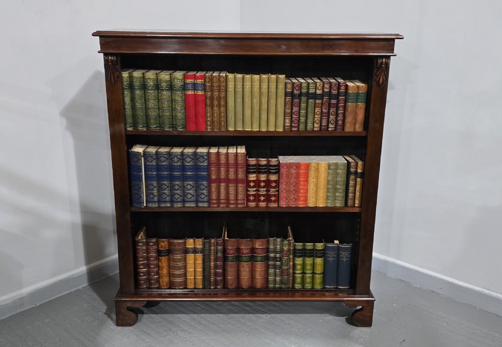 A Victorian mahogany open bookcase featuring three adjustable shelves filled with leather-bound books, flanked by carved corbels. View VII