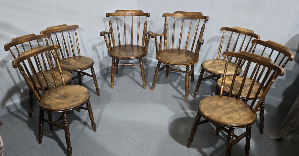 A set of eight antique warm brown wooden kitchen chairs with spindle backrests, turned legs, and contoured seats, including two armchairs. View IV