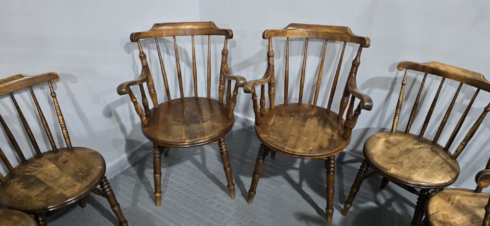 A set of eight antique warm brown wooden kitchen chairs with spindle backrests, turned legs, and contoured seats, including two armchairs. View VII
