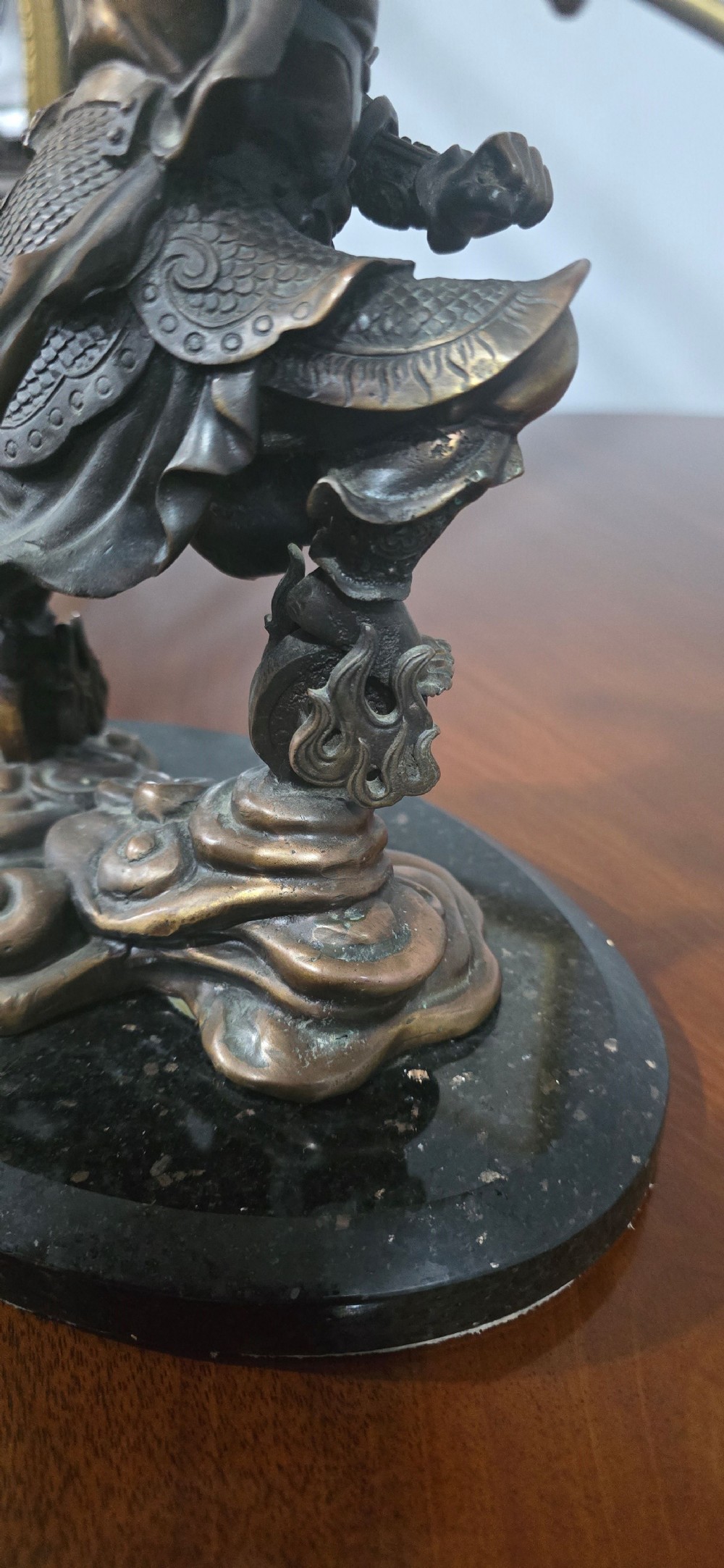 A detailed bronze sculpture depicting the Chinese mythological figure Ne Zha holding a spear, mounted on a circular black marble base. View XIV
