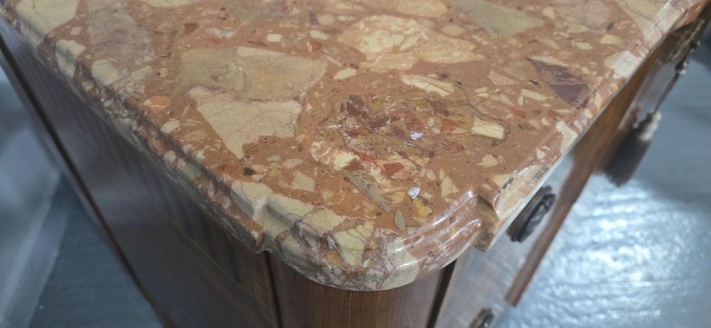 A French marquetry chest of drawers featuring inlaid urn and floral motifs, a contoured pink marble top, and cabriole legs. View VIII