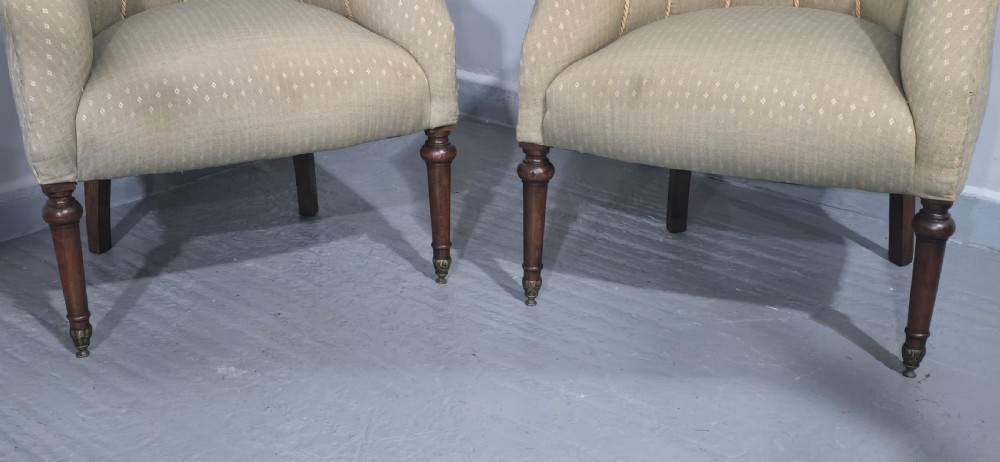 A pair of French walnut tub chairs upholstered in light beige patterned fabric with channelled backrests and turned wooden legs. View IV