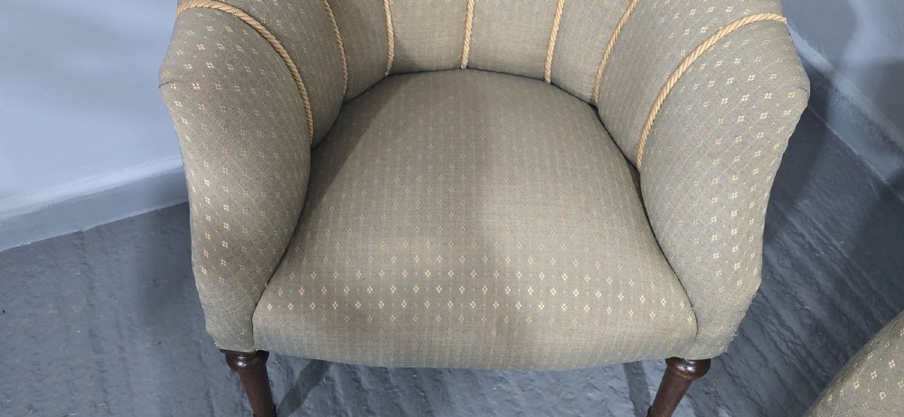 A pair of French walnut tub chairs upholstered in light beige patterned fabric with channelled backrests and turned wooden legs. View VI