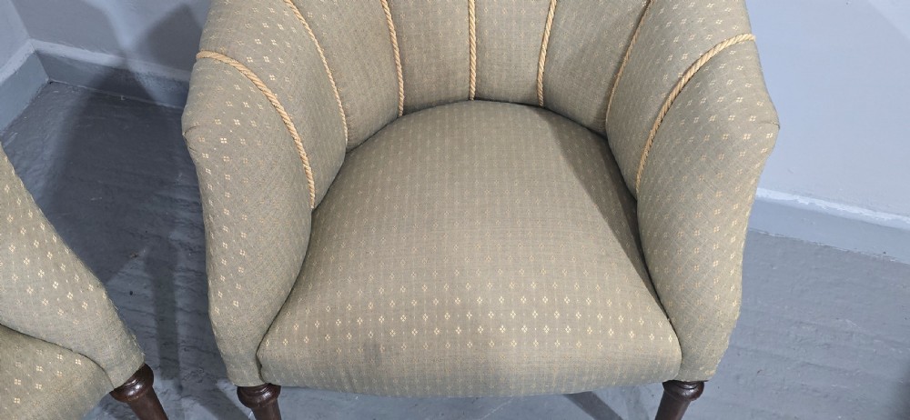 A pair of French walnut tub chairs upholstered in light beige patterned fabric with channelled backrests and turned wooden legs. View VIII