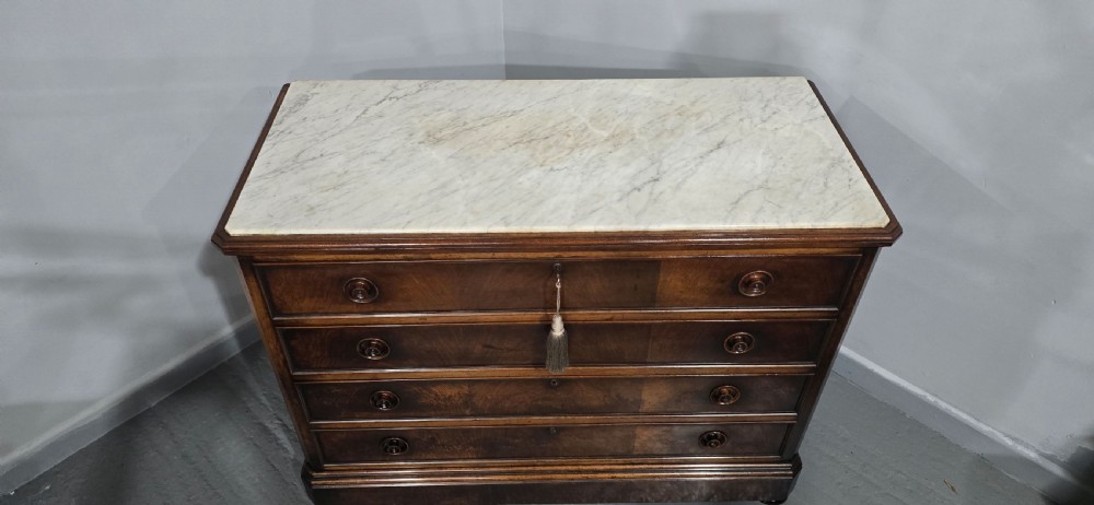 A nineteenth-century French walnut commode with four drawers, turned knobs, and a flat top. View IV