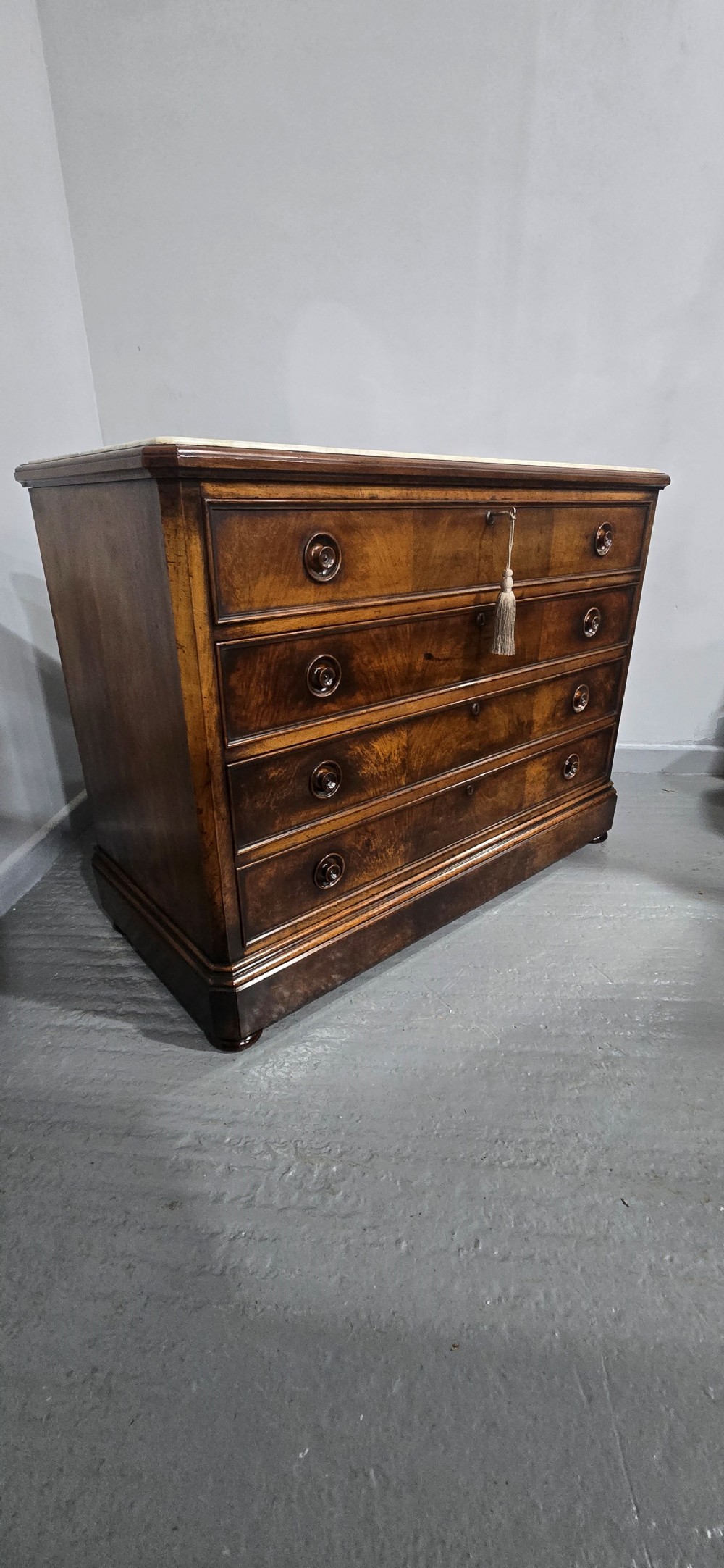 A nineteenth-century French walnut commode with four drawers, turned knobs, and a flat top. View V