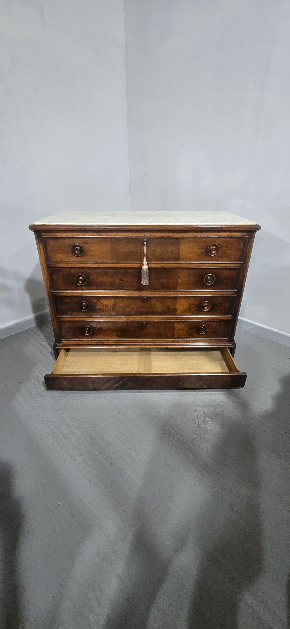 A nineteenth-century French walnut commode with four drawers, turned knobs, and a flat top. View XI