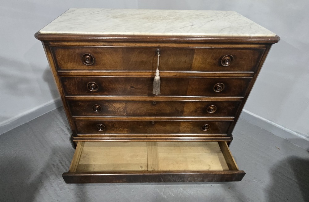 A nineteenth-century French walnut commode with four drawers, turned knobs, and a flat top. View XII