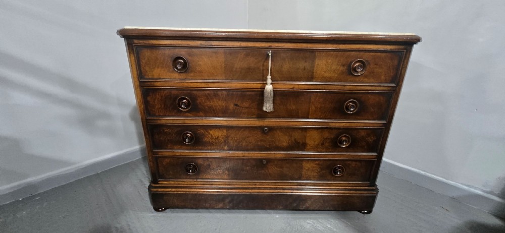 A nineteenth-century French walnut commode with four drawers, turned knobs, and a flat top. View XV