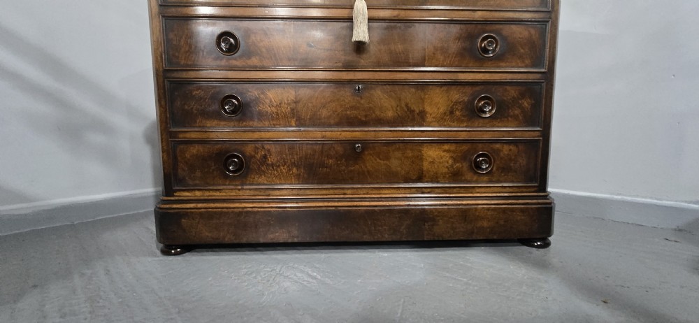 A nineteenth-century French walnut commode with four drawers, turned knobs, and a flat top. View XVIII
