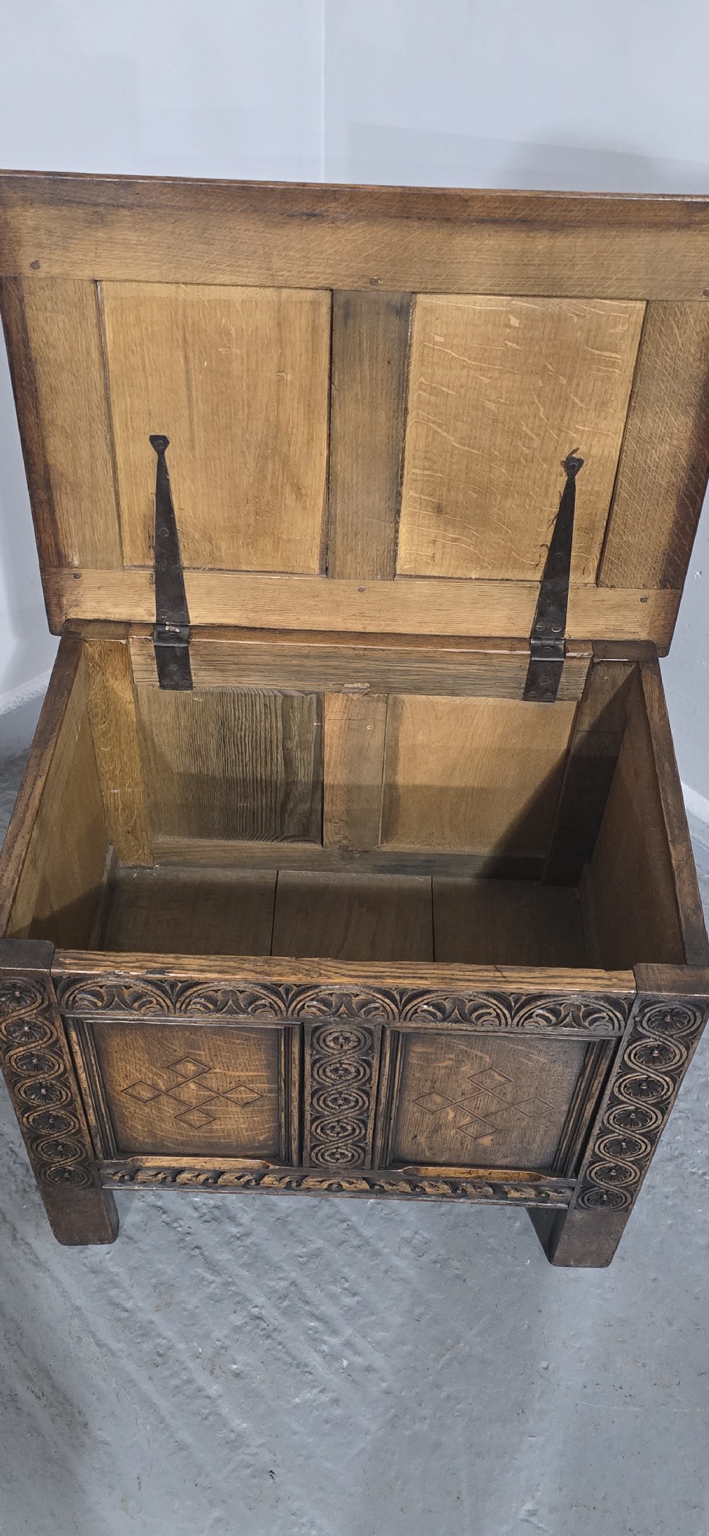 A small dark oak coffer with carved detail, geometric panel inlays, and floral guilloche borders. View XI